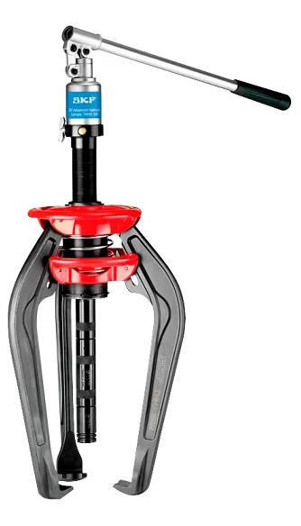 Najpotężniejszy Zintegrowany Ściągacz SKF TMMA 100H w DAKAM Obraz jest ucieleśnieniem maksymalnej mocy w kompaktowej formie. Prezentuje najsilniejszy model z serii zintegrowanych ściągaczy &ndash; SKF TMMA 100H. Kompozycja ma na celu wizualne podkreślenie r&oacute;żnicy skali i siły (100 kN / 10 ton) w por&oacute;wnaniu do mniejszych modeli, przy jednoczesnym zachowaniu mobilności. Całość osadzona jest w realiach profesjonalnego serwisu wspieranego przez autoryzowanego polskiego dystrybutora DAKAM. Dominują barwy: głęboka czerń korpusu, szczotkowana stal ramion i czerwień (uchwyt/dźwignia). 10 ton siły demontażu w jednym narzędziu: W centrum uwagi, na wzmocnionym stole warsztatowym (sugerującym pracę z cięższymi elementami), dominuje ściągacz hydrauliczny SKF TMMA 100H: &bull;	Masywny Korpus: Widoczny jest korpus urządzenia, kt&oacute;ry jest wyraźnie większy i bardziej masywny niż w modelu 75H. To wizualizacja siły 100 kN (10 ton), kt&oacute;ra jest generowana wewnętrznie, bez potrzeby podłączania zewnętrznych pomp. &bull;	Ergonomiczna Dźwignia: Długa, solidna dźwignia pompy jest uchwycona w pozycji gotowej do pracy. Ujęcie sugeruje, że mimo ogromnej siły, narzędzie jest obsługiwane ręcznie, w spos&oacute;b ergonomiczny. &bull;	Wydłużone Ramiona: Prezentowane są długie ramiona ściągacza, kt&oacute;re pozwalają na głęboki chwyt (większy zasięg niż w mniejszych modelach). Mechanizm sprężynowy EasyPull jest widoczny, pokazując, jak ramiona automatycznie zaciskają się za demontowanym elementem. &bull;	Zaw&oacute;r Bezpieczeństwa: Detal na korpusie &ndash; zaw&oacute;r przeciążeniowy, kt&oacute;ry jest gwarantem bezpieczeństwa przy operowaniu tak dużymi siłami. &bull;	Marka Premium: Na czarnym tle korpusu widoczne jest kontrastowe, białe logo "SKF" oraz wyraźne oznaczenie modelu "TMMA 100H", co pozycjonuje produkt jako topowe rozwiązanie w swojej klasie. Sprawdzony Polski Dystrybutor DAKAM: Tło jest subtelnie rozmyte, ale buduje autorytet dostawcy: &bull;	Duża Walizka: Obok narzędzia stoi otwarta, duża walizka transportowa dedykowana dla modelu 100H (często z k&oacute;łkami lub solidnym uchwytem ze względu na wagę). &bull;	Magazyn DAKAM: W tle widać regały z produktami Heavy Duty, co potwierdza, że DAKAM specjalizuje się w dostarczaniu narzędzi do najcięższych zadań. &bull;	Logo Dystrybutora: W dyskretnym, ale widocznym miejscu umieszczone jest logo DAKAM, z dopiskiem "Autoryzowany Dystrybutor Narzędzi SKF". Obraz niesie jasny komunikat: "W DAKAM dostępny jest najsilniejszy zintegrowany ściągacz na rynku &ndash; SKF TMMA 100H. To 10 ton czystej siły hydraulicznej, zamknięte w przenośnym urządzeniu, gotowym do demontażu dużych łożysk i k&oacute;ł zębatych bez zewnętrznego zasilania".