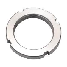 Obraz przedstawia nakrętki łożyskowe (ang. bearing nuts). Nakrętki te mają charakterystyczny wygląd: są okrągłe, wykonane ze stali i posiadają gwint wewnętrzny, kt&oacute;ry służy do mocowania na wale lub tulei łożyskowej. Na obwodzie widoczne są wycięcia (rowki), kt&oacute;re służą do osadzania klucza specjalnego lub podkładki zabezpieczającej. Najpopularniejszym typem są nakrętki o oznaczeniu KM, kt&oacute;re są zazwyczaj używane w połączeniu z podkładkami z ząbkami MB. Taki zestaw zapewnia pewne i stabilne osiowe ustalenie łożyska, zapobiegając jego samoczynnemu poluzowaniu się pod wpływem wibracji czy obciążeń.