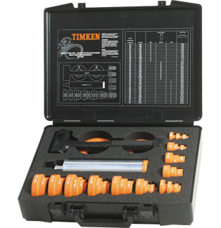 DAKAM – Twój ekspert od narzędzi TIMKEN. Gwarancja jakości i dostępności. Obraz jest ucieleśnieniem amerykańskiej inżynierii i profesjonalizmu w dziedzinie utrzymania ruchu, które są synonimami marki TIMKEN. Kompozycja łączy w sobie solidny, techniczny wizerunek kompletnego zestawu narzędzi do montażu na zimno z zaufaniem i dostępnością, jakie budzi autoryzowany polski dystrybutor DAKAM. Dominują w niej charakterystyczne dla TIMKEN barwy – głęboka czerń i czerwień – oraz przemysłowe odcienie stali i twardego tworzywa. W centrum uwagi, na czystej, industrialnej powierzchni (np. metalowym stole warsztatowym lub białym tle), znajduje się otwarta, solidna walizka transportowa zawierająca kompletny zestaw montażowy TIMKEN: • Profesjonalna walizka: Wytrzymała walizka w charakterystycznym czarnym lub czerwonym kolorze z wyraźnym logo "TIMKEN". Jej wnętrze jest wyprofilowane (np. piankowa wytłoczka), idealnie dopasowane do wszystkich elementów zestawu, co podkreśla porządek i profesjonalizm. • Pierścienie udarowe: Widoczny jest komplet precyzyjnych pierścieni udarowych (zazwyczaj czarnych, wykonanych z twardego, odpornego na uderzenia tworzywa). Są one starannie ułożone w walizce. Ujęcie makro może eksponować wyraźne oznaczenia rozmiarów na każdym pierścieniu, co podkreśla łatwość doboru. • Tuleje udarowe: Zestaw solidnych, aluminiowych lub stalowych tulei o różnych długościach, służących do bezpiecznego przeniesienia siły. • Młotek bezodrzutowy: W zestawie znajduje się również charakterystyczny młotek bezodrzutowy (dead-blow hammer), często z czerwono-czarną rękojeścią, który wizualnie komunikuje metodę pracy – precyzyjne uderzanie bez ryzyka uszkodzenia komponentów. • Wizualne przesłanie: Cały zestaw wizualnie komunikuje kluczową zasadę prawidłowego montażu – równomierne przykładanie siły tylko do właściwego pierścienia łożyska, aby uniknąć uszkodzenia elementów tocznych. Tło jest subtelnie rozmyte (efekt bokeh), ale jednoznacznie wskazuje na profesjonalną dystrybucję na terenie Polski: • Nowoczesny magazyn DAKAM: W tle widać rzędy wysokich regałów magazynowych, wypełnionych uporządkowanymi, oryginalnymi, czerwono-czarnymi opakowaniami TIMKEN. Duża ilość towaru na stanie wizualnie potwierdza status "sprawdzonego dystrybutora". • Logo Dystrybutora: W dyskretnym, ale widocznym miejscu umieszczone jest logo DAKAM, z dopiskiem "Autoryzowany Dystrybutor TIMKEN" lub "Centrum Utrzymania Ruchu", co buduje jego markę jako zaufanego partnera w dostawach narzędzi diagnostycznych. Obraz niesie jasny komunikat: "Jako autoryzowany polski dystrybutor DAKAM, posiadamy na stanie profesjonalne, amerykańskie zestawy do montażu łożysk na zimno TIMKEN, niezbędne do zapewnienia bezpiecznego i bezuszkodzeniowego montażu w utrzymaniu ruchu".