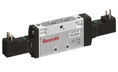 Elektrozawory REXROTH (Aventics) Zdjęcie zrobione z bliska przedstawia zaawansowaną, modułową wyspę zaworową firmy AVENTICS (dawniej Bosch Rexroth Pneumatics), będącą kluczowym elementem sterującym w automatyce przemysłowej. Wyspa złożona jest z szeregu połączonych ze sobą elektrozaworów, osadzonych na wspólnym bloku. Dominują jasne, szare lub metaliczne odcienie obudowy. Na górze widoczny jest moduł komunikacyjny z widocznymi diodami LED (zielone, żółte), sygnalizującymi stan pracy i komunikację sieciową (np. Fieldbus lub EtherCAT). Z boku wystają liczne gniazda i porty przyłączeniowe na węże pneumatyczne oraz złącza elektryczne. Całość jest schludna, a wygrawerowane oznaczenia modelu i specyfikacji technicznej na modułach podkreślają profesjonalny charakter i precyzję wykonania.