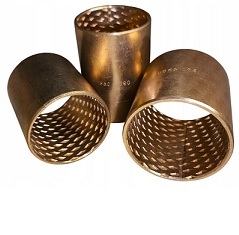 Opis obrazu: Fotografia produktowa przedstawia r&oacute;żnorodne tuleje ślizgowe z brązu, kluczowe komponenty w budowie maszyn i urządzeń. Na zdjęciu widoczne są zar&oacute;wno tuleje z litego brązu (np. RG7), jak i tuleje ze spiek&oacute;w brązu, kt&oacute;re r&oacute;żnią się wykończeniem powierzchni &ndash; od gładkiego połysku po matową, porowatą strukturę nasączoną olejem. R&oacute;żnorodność kształt&oacute;w, w tym tuleje proste (cylindryczne) oraz tuleje kołnierzowe, ilustruje szerokie możliwości zastosowania tych łożysk ślizgowych. Złocista barwa brązu świadczy o wysokiej zawartości miedzi, co przekłada się na doskonałe właściwości ślizgowe, odporność na korozję i wysoką nośność. Jest to idealny wyb&oacute;r do aplikacji wymagających niezawodności w trudnych warunkach pracy.