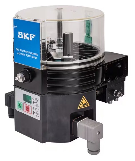 Obraz jest ucieleśnieniem kompaktowej, zintegrowanej automatyzacji smarowania, kt&oacute;re są synonimami zaawansowanych system&oacute;w SKF. Kompozycja łączy w sobie sterylny, high-tech'owy wizerunek kompletnej jednostki pompującej TLMP 1008 z profesjonalizmem i dostępnością, jakie budzi autoryzowany polski dystrybutor DAKAM. Dominują w niej ikoniczne barwy SKF &ndash; intensywny niebieski &ndash; oraz przezroczyste elementy zbiornika. W centrum uwagi, na czystej, industrialnej powierzchni (np. metalowym stole warsztatowym lub białym tle), znajduje się automatyczna smarownica wielopunktowa SKF TLMP 1008/230V: &bull;	Zintegrowana jednostka: Prezentowana jest kompletna, kompaktowa jednostka, kt&oacute;ra łączy w sobie pompę, zbiornik i sterownik. &bull;	Kluczowy detal &ndash; 8 wyjść: Wyraźnie widoczny jest blok dystrybucyjny z maksymalnie 8 wyjściami (portami). To wizualnie komunikuje jej przeznaczenie do bezpośredniego smarowania wielopunktowego wielu element&oacute;w maszyny z jednej, centralnej jednostki. &bull;	Przezroczysty zbiornik: Widoczny jest przezroczysty zbiornik na smar (o pojemności ok. 1 litra) z mieszadłem, co umożliwia łatwą wizualną kontrolę poziomu środka smarnego. &bull;	Zasilanie 230V: Widoczny jest kabel zasilający (sieciowy), co podkreśla zasilanie napięciem 230V AC i możliwość samodzielnej pracy (standalone) bez konieczności integracji z PLC maszyny. &bull;	Marka Premium: Na solidnej obudowie (niebieskiej lub czarnej) widoczne jest wyraźne, oryginalne logo "SKF" oraz oznaczenie modelu "TLMP 1008 / 230VAC", co jest gwarancją autentyczności i światowej klasy technologii. Tło jest subtelnie rozmyte (efekt bokeh), ale jednoznacznie wskazuje na profesjonalną dystrybucję na terenie Polski: &bull;	Nowoczesny magazyn DAKAM: W tle widać rzędy wysokich regał&oacute;w magazynowych, wypełnionych uporządkowanymi, oryginalnymi, niebieskimi opakowaniami SKF. Duża ilość towaru na stanie wizualnie potwierdza status "sprawdzonego dystrybutora". &bull;	Logo Dystrybutora: W dyskretnym, ale widocznym miejscu umieszczone jest logo DAKAM, z dopiskiem "Autoryzowane Centrum System&oacute;w Smarowania" lub "Autoryzowany Dystrybutor SKF". Obraz niesie jasny komunikat: "Jako autoryzowany polski dystrybutor DAKAM, posiadamy na stanie kompaktowe smarownice wielopunktowe SKF TLMP 1008/230V, idealne do automatycznego smarowania wielu punkt&oacute;w w maszynach, pracujące jako samodzielna jednostka zasilana z sieci 230V".